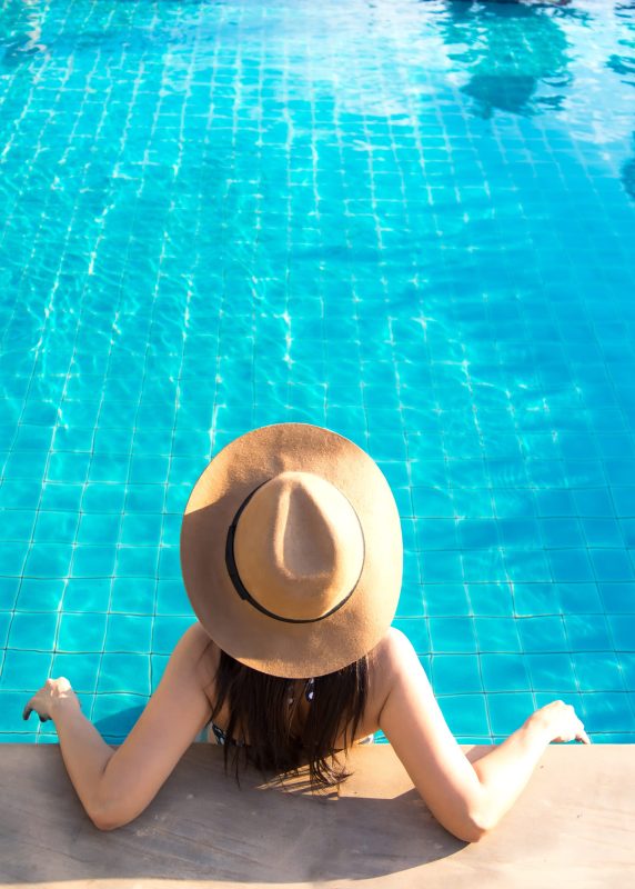 Women relaxing near luxury swimming pool Women relaxing near luxury swimming pool